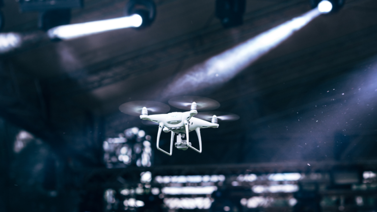 Drone flying over crowd in a concert venue to capture content for business marketing. 